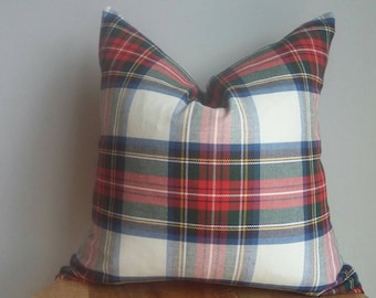 Puede incluir: Una almohada blanca con un patrón de cuadros rojos, verdes, azules y amarillos.