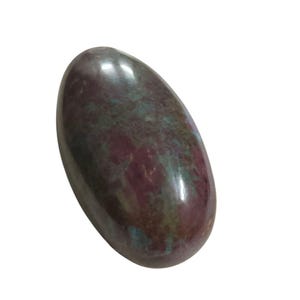 Puede incluir: Una piedra preciosa pulida de forma ovalada, con una mezcla de tonos burdeos, verde azulado y verdes. La piedra tiene una superficie lisa y brillante y un aspecto natural y orgánico. La piedra preciosa está sobre un fondo blanco.