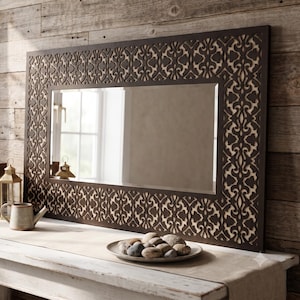 May include: A rectangular wall mirror featuring a dark brown frame with an intricate, laser-cut geometric pattern layered over a light-colored backing. The mirror has a smooth, reflective glass surface and a wide, decorative border design.