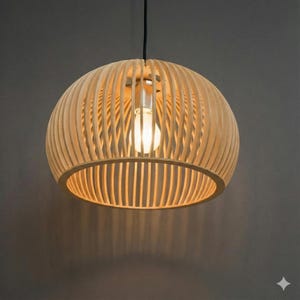 Könnte beinhalten: Eine hängende Holzleuchte in Kugelform. Sie besteht aus dünnen, vertikalen Holzlatten, die eine Kugel bilden. Im Inneren ist eine einzelne Glühbirne zu sehen, die ein warmes Licht ausstrahlt. Die Leuchte hängt an einem schwarzen Kabel.