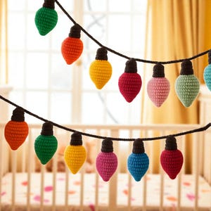 May include: A string of colorful, crocheted light bulbs in various colors, including green, orange, yellow, red, pink, and blue. Each bulb has a black base and is strung on a black cord. The lights are likely for decorative purposes.