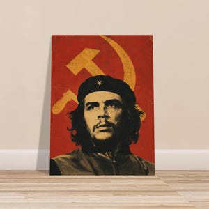 May include: A rectangular poster featuring a high-contrast black and white portrait of a person with long hair wearing a beret with a star. The background is a deep red colour with a large, faded yellow hammer and sickle symbol overlaid.