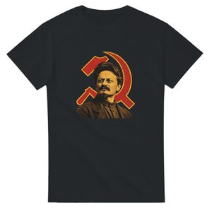 May include: A black short-sleeved t-shirt featuring a graphic print on the chest. The design displays a portrait of Leon Trotsky in sepia tones, positioned in front of a large, stylised red hammer and sickle symbol with a yellow outline.