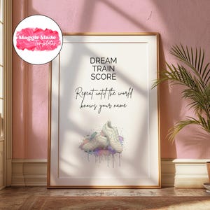 K&ouml;nnte beinhalten: Gerahmter Kunstdruck mit goldenem Rahmen. Der Druck zeigt die Worte "DREAM TRAIN SCORE" &uuml;ber dem Satz "Repeat until the world knows your name". Darunter befinden sich wei&szlig;e Fu&szlig;ballschuhe mit farbenfrohen Aquarellakzenten.