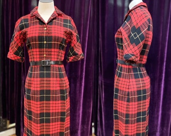May include: A red, black, and gold plaid dress with a collared neckline and short sleeves. The dress has a black belt and is fitted.