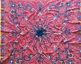 May include: A vintage paisley shawl with a red background and intricate blue and white floral patterns. The shawl has a fringed border with a variety of colors, including red, blue, green, and yellow.