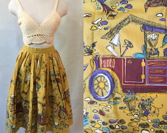 May include: A yellow midi skirt with a vintage-inspired print of cars, houses, and flowers. The skirt is pleated and has a full silhouette.