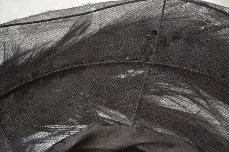 Pode incluir: Close-up de um tecido de malha preto com uma trama fina. O tecido est&aacute; ligeiramente enrugado e tem uma textura macia e delicada.