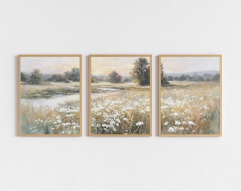 Puede incluir: Conjunto de tres láminas artísticas enmarcadas con paisajes. Cada lámina presenta una serena escena de pradera con un río, árboles y flores silvestres. La obra de arte está realizada en tonos suaves y apagados de beige, verde y blanco, con un marco dorado cálido.