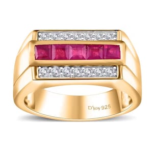 May include: A gold-toned ring featuring a rectangular design with a row of five square, vibrant red gemstones. Above and below the red stones are rows of small, clear gemstones. The ring is marked with "D'joy 925".