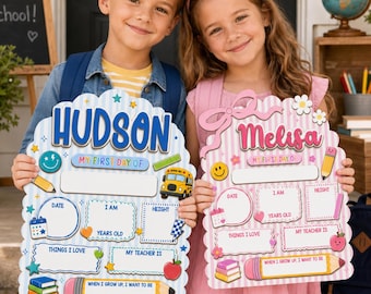 May include: Two personalized school signs with scalloped edges. The blue sign features the name Hudson, while the pink sign features the name Melisa. Both boards include sections for date, age, height, teacher, and interests, decorated with school-themed icons.