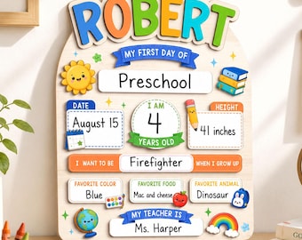 May include: A wooden milestone board for the first day of preschool featuring the name ROBERT in colorful letters. It includes sections for date, age, height of 41 inches, career goal, favorite color, food, animal, and teacher name with illustrations.