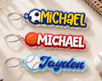 May include: Three custom acrylic keychains with metal rings. The top keychain features a soccer ball and the name MICHAEL in yellow on a blue background. The middle one shows a basketball and the name MICHAEL in white on red. The bottom one displays a baseball and the name Jayden in blue on light blue.