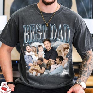 May include: A charcoal gray short-sleeve t-shirt featuring the text BEST DAD in a metallic silver font. Below the text is a collage of various family photographs showing a parent with children in different poses against a cloudy background.