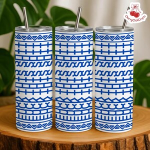 Puede incluir: Tres vasos aislados blancos con patrones geom&eacute;tricos azules y pajitas plateadas. Los vasos tienen un dise&ntilde;o repetitivo de l&iacute;neas horizontales, cruces y formas onduladas. Los vasos est&aacute;n sobre una superficie de madera.