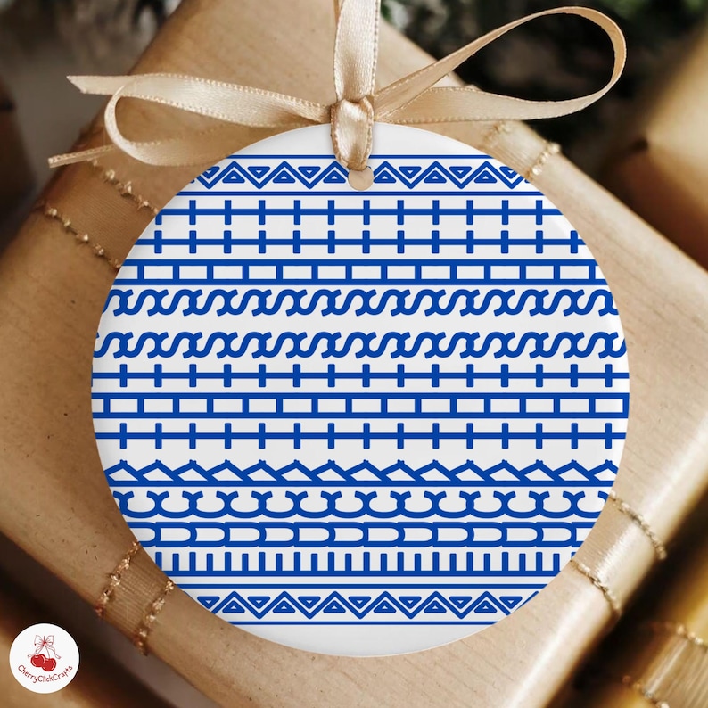 Puede incluir: Adorno navide&ntilde;o redondo de cer&aacute;mica blanca con un patr&oacute;n geom&eacute;trico azul. El dise&ntilde;o presenta bandas horizontales de l&iacute;neas, zigzags y formas onduladas. Se adjunta una cinta dorada para colgarlo. Art&iacute;culo decorativo.