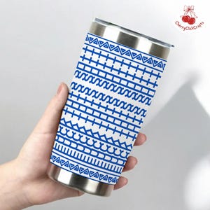 Puede incluir: Un vaso de acero inoxidable con un dise&ntilde;o geom&eacute;trico azul sobre fondo blanco. El dise&ntilde;o incluye tri&aacute;ngulos, l&iacute;neas y curvas. El vaso tiene una tapa y una base plateadas.