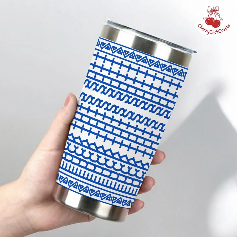 Puede incluir: Un vaso de acero inoxidable con un dise&ntilde;o geom&eacute;trico azul sobre fondo blanco. El dise&ntilde;o incluye tri&aacute;ngulos, l&iacute;neas y curvas. El vaso tiene una tapa y una base plateadas.