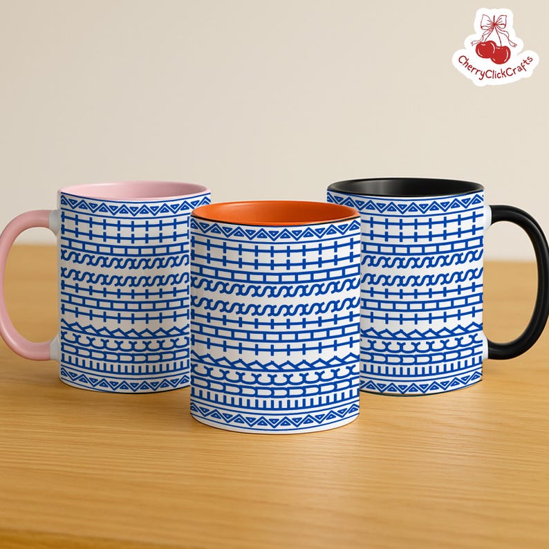 Puede incluir: Tres tazas de cer&aacute;mica con motivos geom&eacute;tricos azules sobre fondo blanco. Una tiene el interior y el asa rosas, otra el interior naranja y la tercera el interior y el asa negros. Las tazas est&aacute;n sobre una superficie de madera.