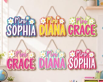 May include: Six rectangular hanging wall signs with scalloped edges, each featuring a striped background, the text "Mrs." in script, a name in block letters, and white flower accents. The signs display the names Sophia, Diana, and Grace.
