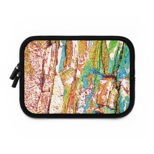 May include: A rectangular laptop sleeve with a colorful abstract design. The design features a textured pattern in shades of orange, green, blue, and white, with a black border and zipper.