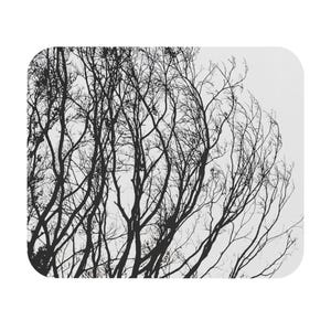 May include: Black and white mousepad featuring a silhouetted tree branch design. The branches are intricate and detailed against a white background. The mousepad has rounded corners.