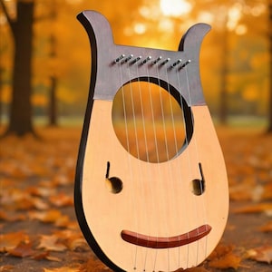 May include: A wooden lyre with a light brown body and dark brown accents. The instrument has a large circular sound hole and a smiling face design. The strings are silver, and the background is a blurred autumn scene with fallen leaves.