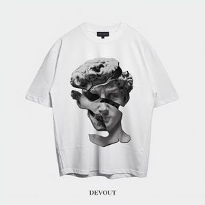 Pode incluir: Camiseta branca com um gráfico em preto e branco de uma cabeça de estátua fragmentada. O design é centralizado e inclui a palavra "DEVOUT" na parte inferior. A camiseta tem gola redonda clássica e mangas curtas.
