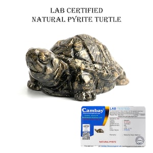 Könnte beinhalten: Eine geschnitzte Pyrit-Schildkrötenfigur. Die Schildkröte hat eine dunkle Metallicfarbe mit Goldflecken. Das Bild enthält eine Laborzertifizierungskarte mit Details über die Pyrit-Schildkröte. Der Text auf dem Bild lautet "LAB CERTIFIED NATURAL PYRITE TURTLE."