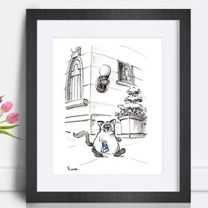 May include: Black and white framed art print of a cartoon cat walking on a sidewalk, holding a small blue bag. The background features a building with architectural details and a street lamp. A vase of pink and purple tulips is in the foreground.