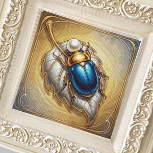 Può includere: Un'opera d'arte incorniciata con un'illustrazione dettagliata di uno scarabeo blu e oro su una foglia d'argento. L'opera è ambientata su uno sfondo dorato e incorniciata in una cornice bianca ornata.