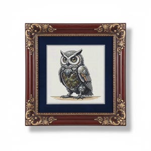 May include: Framed artwork featuring a detailed illustration of an owl with metallic and mechanical elements. The owl has large yellow eyes and a detailed design. The frame is dark brown with gold accents, and the artwork is set against a navy blue background.