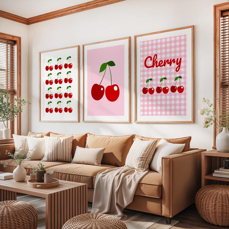 May include: Three framed art prints featuring cherry designs. One print displays rows of cherries, another shows two cherries, and the third has a gingham background with the word "Cherry" and cherries.