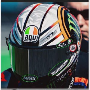 Op de afbeelding: Visor sponsorstickers en stickers voor de helm van Marco Bezzecchi. De helm heeft een groen vizier en sponsorlogo's, waaronder Oakley, AGV en F.LLI FRANCHINI. Het ontwerp bevat rode, witte en oranje accenten.