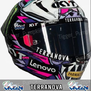 Könnte beinhalten: Ein Motorradhelm mit einem mehrfarbigen Grafikdesign in Pink, Lila, Schwarz und Weiß. Das Visier ist mit Sponsorenaufklebern versehen, darunter die Logos von Viviani, Industria Chimica Panzeri, Terranova, Lenovo und Parmacotto.