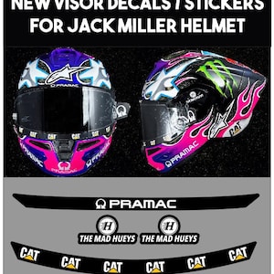 Peut inclure: Un ensemble d'autocollants pour visière de casque Jack Miller, comprenant des bandes noires avec le texte blanc PRAMAC, THE MAD HUEYS et CAT. L'image montre deux vues d'un casque violet, rose et noir avec des autocollants de marque assortis.