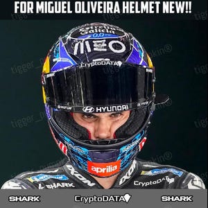 Peut inclure: Un casque de moto avec des graphismes bleus, noirs et rouges et des logos de sponsors dont Estrella Galicia 0,0, MEO, CryptoDATA, Shark, Hyundai et Aprilia. La visière affiche le logo Hyundai. Le texte indique VISOR SPONSOR DECALS / STICKERS.
