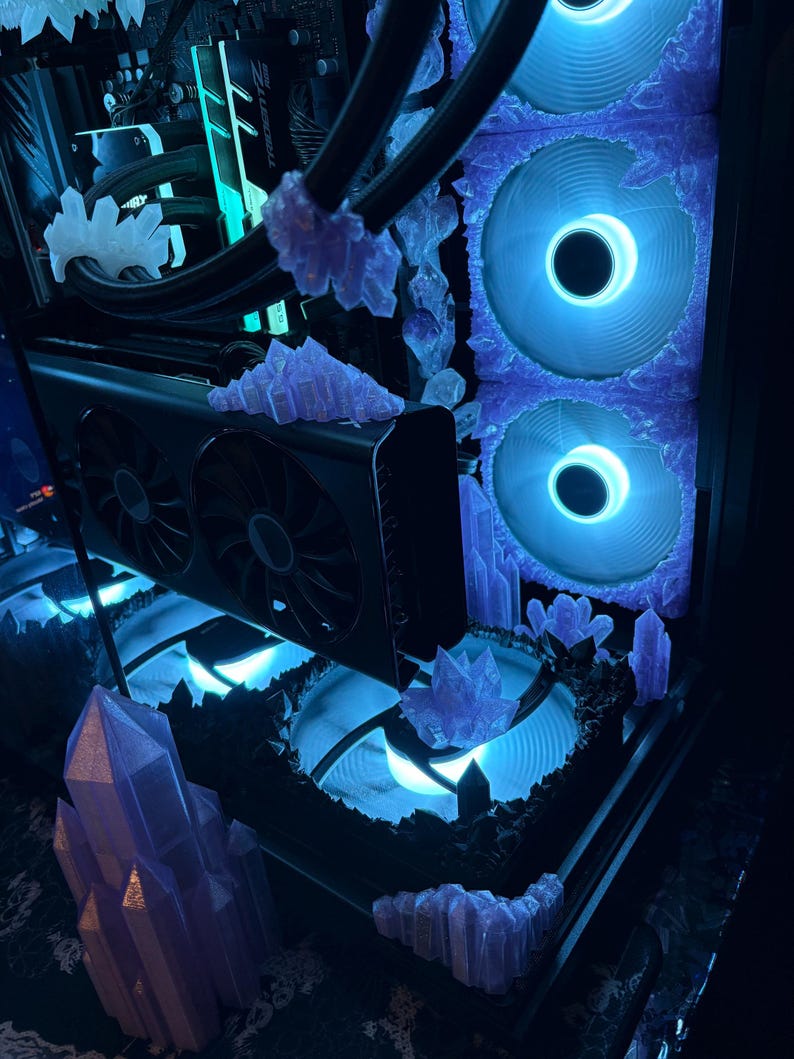 K&ouml;nnte beinhalten: Ein individuell angefertigtes Computergeh&auml;use mit einer einzigartigen &Auml;sthetik. Das Innere ist mit blauen Lichtern beleuchtet und mit kristallartigen Strukturen verziert. Die L&uuml;fter und Komponenten sind sichtbar, was ein futuristisches und k&uuml;nstlerisches Design ergibt.