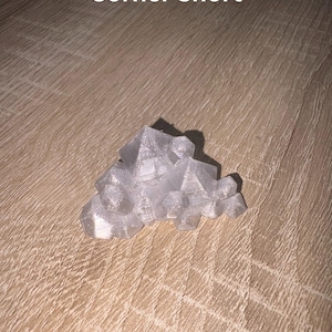 May include: A translucent, geometric sculpture with a crystalline appearance. The object is composed of multiple angular shapes, creating a clustered, abstract form. The text "Corner Short" is visible in white.