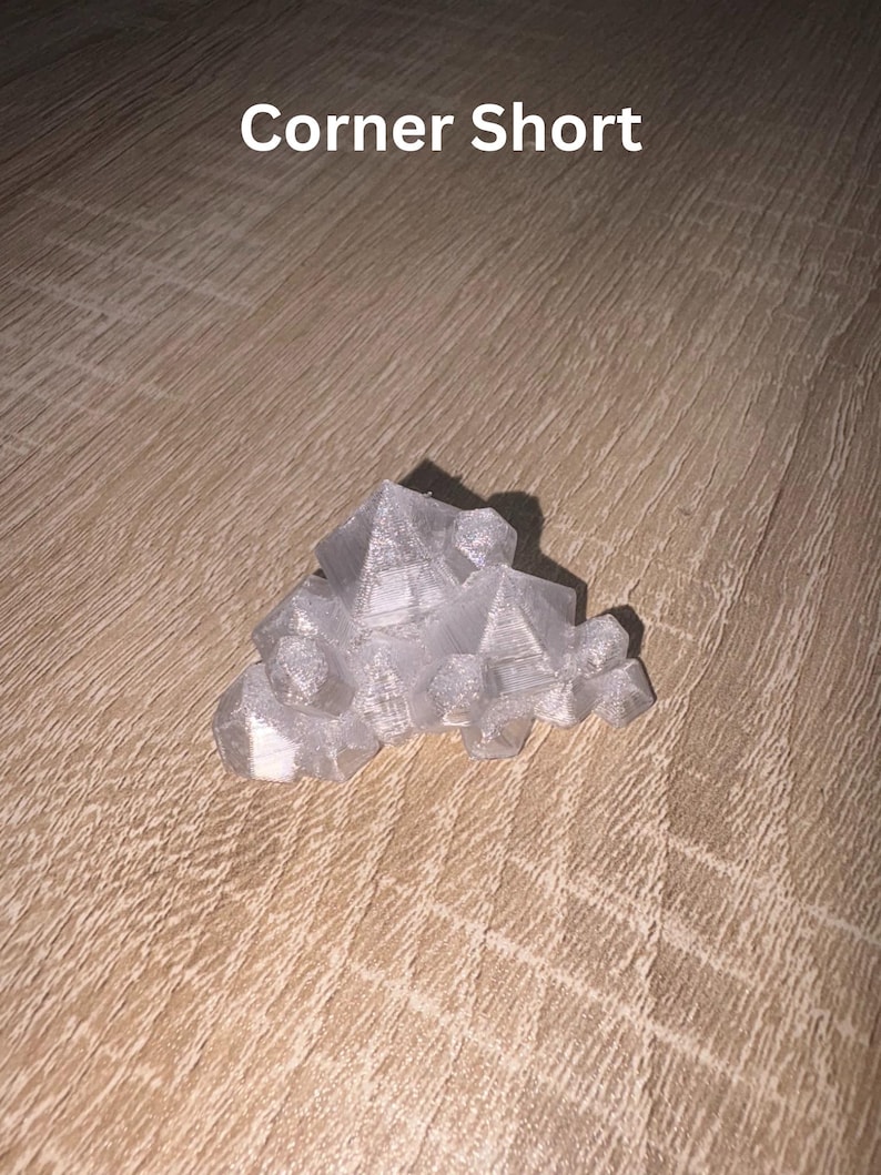 May include: A translucent, geometric sculpture with a crystalline appearance. The object is composed of multiple angular shapes, creating a clustered, abstract form. The text "Corner Short" is visible in white.