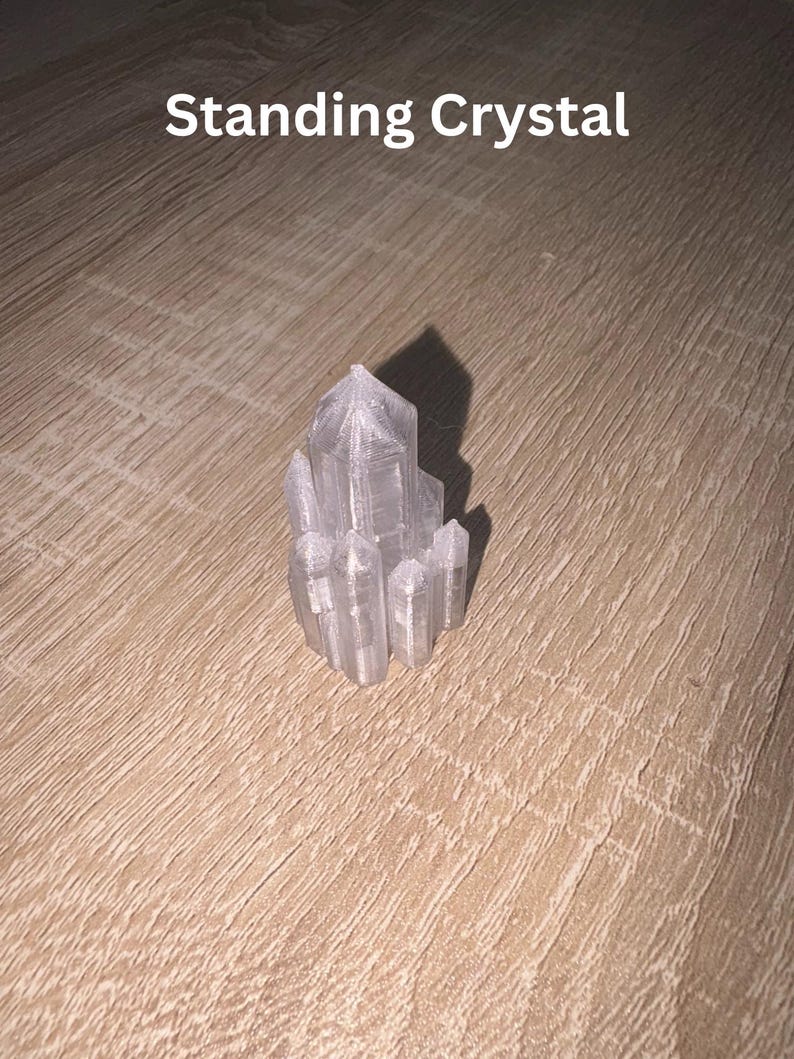 May include: A clear, standing crystal formation with multiple pointed facets. The crystal is positioned on a light brown wooden surface. The text "Standing Crystal" is displayed above the crystal.