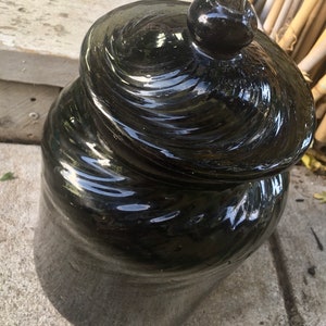 May include: A black ceramic jar with a lid. The jar has a swirl design and a glossy finish.
