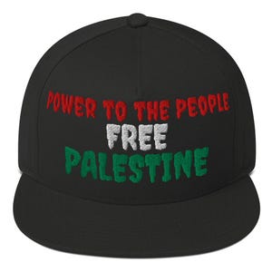 Op de afbeelding: Zwarte baseballcap met geborduurde tekst in rood, wit en groen. De tekst luidt "POWER TO THE PEOPLE FREE PALESTINE". De cap heeft een platte klep en een ronde kroon.