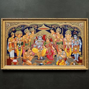 Op de afbeelding: Een ingelijste, kleurrijke illustratie die een religieuze scène met meerdere figuren uitbeeldt. De centrale figuren zitten op een troon, omringd door andere figuren in sierlijke kleding. Het kunstwerk is ingelijst in een goudkleurige lijst.