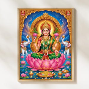 May include: A vibrant, framed artwork depicting a seated deity on a pink lotus flower. The figure wears a green and red sari, adorned with gold jewelry, and holds lotus flowers. Two white elephants flank the central figure, set against a blue backdrop.