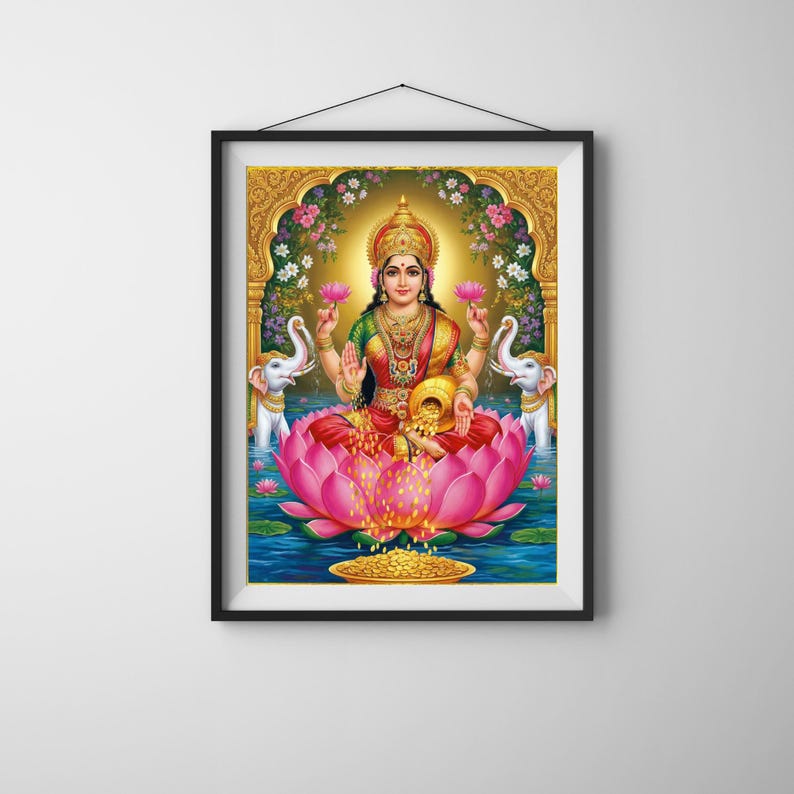 May include: Framed print of Lakshmi, the Hindu goddess of wealth, prosperity, and beauty. She is depicted seated on a large pink lotus flower, holding lotus flowers in two hands. Two white elephants flank her, and a golden arch frames the scene.