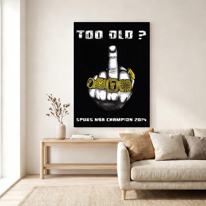 May include: A black poster featuring a white illustration of a hand making a middle finger gesture, with four gold championship rings on the fingers. The text reads "TOO OLD ?" at the top and "SPURS NBA CHAMPION 2014" at the bottom in white.