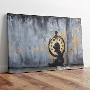 May include: A canvas print featuring a black silhouette of a child sitting in front of a clock. The clock is painted in black with a yellow center. The background is a textured, weathered wall with gray and yellow paint.