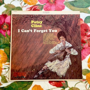 May include: Vintage Patsy Cline "I Can't Forget You" vinyl record album cover. The cover features a sepia-toned illustration of Patsy Cline playing a guitar. The album title and artist's name are in yellow text.