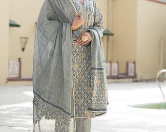 May include: A grey three-piece outfit consisting of a long-sleeved tunic, straight-leg trousers, and a matching dupatta. The fabric features a repeating leaf pattern in dark grey and beige, with a subtle striped texture throughout the garments.